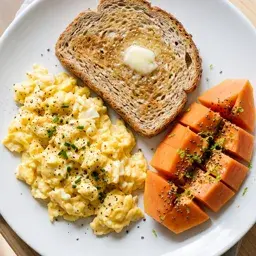 Café da manhã: ovos mexidos, pão integral e mamão